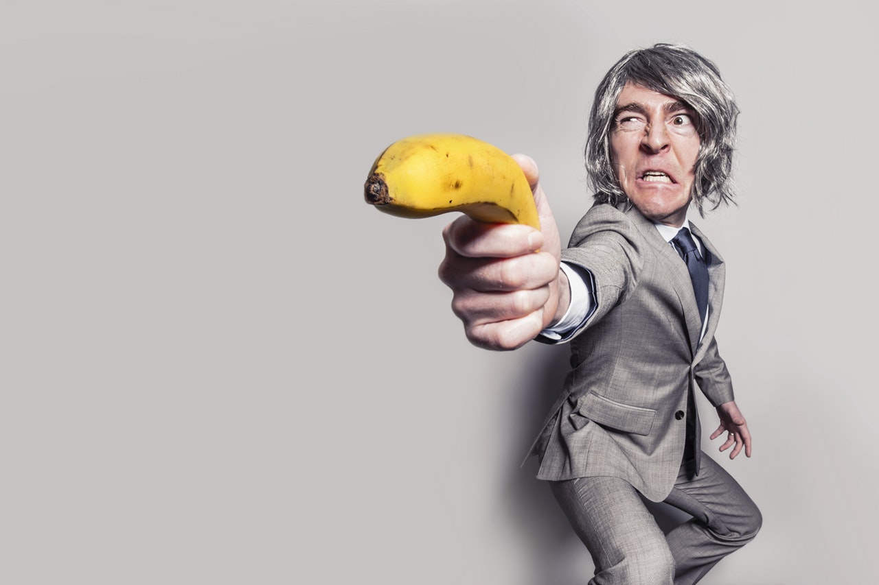 angry man in grey suit pointing a banana